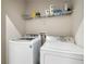 Laundry room with a front load washer and dryer, with shelving above for storage at 10196 Cross Timber Ter, Land O Lakes, FL 34638