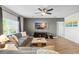 Comfortable living room featuring wood-look tile floors, a ceiling fan, a gray accent wall, and a gray sofa at 10196 Cross Timber Ter, Land O Lakes, FL 34638