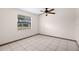 Bright bedroom featuring white tile floor, a ceiling fan, and large windows at 112 Rosewood Ct, Palm Harbor, FL 34685