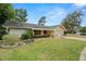 Charming single-story home with a well-maintained front yard, mature trees, and attached two-car garage at 112 Rosewood Ct, Palm Harbor, FL 34685