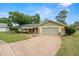 Charming single-story home with a well-maintained front yard, mature trees, and attached two-car garage at 112 Rosewood Ct, Palm Harbor, FL 34685