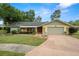 Charming single-story home with a well-maintained front yard, mature trees, and attached two-car garage at 112 Rosewood Ct, Palm Harbor, FL 34685