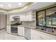 Bright kitchen showcasing granite countertops, mosaic backsplash, and stainless steel appliances at 112 Rosewood Ct, Palm Harbor, FL 34685