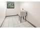 Laundry room with a utility sink, tile flooring, and a window for natural light at 112 Rosewood Ct, Palm Harbor, FL 34685