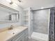 Renovated bathroom with granite vanity and gray-tiled walk-in shower at 1225 26Th N St, St Petersburg, FL 33713