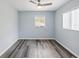 Comfortable bedroom with wood-look flooring, a ceiling fan, and plenty of natural light from two windows at 1225 26Th N St, St Petersburg, FL 33713