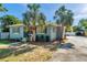 Charming blue home featuring a well-maintained yard, palm trees, and a concrete driveway at 1225 26Th N St, St Petersburg, FL 33713