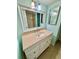 Bathroom featuring a single sink vanity with stone counters, a decorative mirror and blue walls at 1390 Gulf Blvd # 104, Clearwater, FL 33767