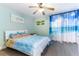 A bedroom with coastal themed decor, ceiling fan, painting and hardwood floors at 1390 Gulf Blvd # 104, Clearwater, FL 33767