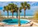 Private in-ground spa with ocean views surrounded by palm trees, located just steps away from the beach at 1390 Gulf Blvd # 104, Clearwater, FL 33767