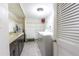 Bright laundry room featuring a washer, shelving, folding table, tile floors, and storage cabinets at 1390 Gulf Blvd # 104, Clearwater, FL 33767