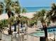 Pool view overlooking the ocean, sandy beach, and palm trees at 1390 Gulf Blvd # 104, Clearwater, FL 33767