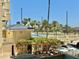 Sunny view of community tennis courts, lush palm trees, and parking at this beautiful property at 1390 Gulf Blvd # 104, Clearwater, FL 33767