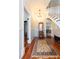 Inviting foyer with wood floors, grand staircase, decorative rug, and stylish accents at 14006 5Th St, Dade City, FL 33525