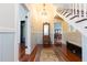 Elegant foyer featuring wood floors, staircase, decorative mirror, and a glimpse into the dining room at 14006 5Th St, Dade City, FL 33525