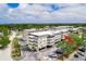 Overhead view showcasing the condo building's layout, parking, landscaping, and nearby trees at 147 Bluff View Dr # 206, Belleair Bluffs, FL 33770