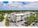 Aerial view of a condo complex with lush landscaping, parking, and stunning architectural design on a sunny day at 147 Bluff View Dr # 206, Belleair Bluffs, FL 33770