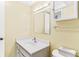Bathroom featuring a well-lit sink with a storage cabinet, a mirror, and a toilet at 147 Bluff View Dr # 206, Belleair Bluffs, FL 33770