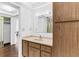 Bright bathroom with a sink, storage cabinet, and well-lit mirror at 147 Bluff View Dr # 206, Belleair Bluffs, FL 33770