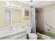 Bathroom showcasing a white vanity, toilet, and tiled shower-tub combination with a shower curtain at 147 Bluff View Dr # 206, Belleair Bluffs, FL 33770