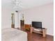A well-lit bedroom with hardwood floors, a ceiling fan, a spacious closet, and a convenient TV stand for entertainment at 147 Bluff View Dr # 206, Belleair Bluffs, FL 33770