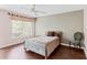 A well-lit bedroom features hardwood floors, a queen-sized bed, a ceiling fan, and a large window with views of the outside at 147 Bluff View Dr # 206, Belleair Bluffs, FL 33770