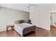 A comfortable bedroom featuring wood floors, a ceiling fan, natural light from a window, and a cozy bed with side table at 147 Bluff View Dr # 206, Belleair Bluffs, FL 33770