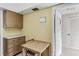 A compact kitchen with laminate countertops, a wooden dining table, and ample cabinet space, with easy access to the hallway at 147 Bluff View Dr # 206, Belleair Bluffs, FL 33770