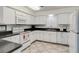 Bright kitchen featuring white cabinetry, tile flooring, and essential appliances for a functional cooking space at 147 Bluff View Dr # 206, Belleair Bluffs, FL 33770