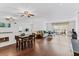 Spacious living room featuring hardwood floors, mirrored wall, ceiling fan, dining table, and abundant natural light at 147 Bluff View Dr # 206, Belleair Bluffs, FL 33770