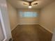 Neutral bedroom with a ceiling fan, large window with blinds, and carpet at 212 S Church Ave # 105, Tampa, FL 33609
