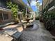 Beautiful courtyard featuring a central fountain, brick-paved walkways, seating, and tropical plants at 212 S Church Ave # 105, Tampa, FL 33609