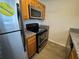 Kitchen featuring wooden cabinets, granite countertops, stainless steel appliances, and tile flooring at 212 S Church Ave # 105, Tampa, FL 33609