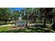 Picturesque scene of Coffee Pot Park with lush trees, paved path, a sign, and people biking and walking at 217 50Th N Ter, St Petersburg, FL 33703