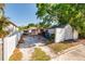 View of the home's driveway with grass and a fenced yard at 217 50Th N Ter, St Petersburg, FL 33703