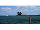 Stunning view of the pier with a unique building structure, blue skies, and a glimpse of a boat passing by at 217 50Th N Ter, St Petersburg, FL 33703