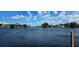 Inviting waterfront view with well-manicured landscaping, tranquil waters, blue sky, and luxury houses across bay at 217 50Th N Ter, St Petersburg, FL 33703