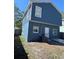Rear exterior view of two-story home with blue siding and small backyard space at 2527 13Th S Ave, St Petersburg, FL 33701