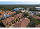 Real estate aerial showcasing Mediterranean-style condos with tile roofs in a lush, vibrant community setting at 264 Seagate Ct, Dunedin, FL 34698