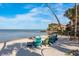 A private sandy beach with colorful lounge chairs overlooking the tranquil waters at 264 Seagate Ct, Dunedin, FL 34698