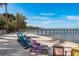 A peaceful beach area with lounge chairs overlooking the pier and serene waters at 264 Seagate Ct, Dunedin, FL 34698