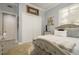 Comfortable bedroom featuring a tufted headboard, decorative rug, and ample natural light from the shuttered window at 264 Seagate Ct, Dunedin, FL 34698