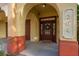 Exterior entrance with an arched doorway, a wooden door with glass panes and sidelights at 264 Seagate Ct, Dunedin, FL 34698