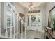 The foyer features a white staircase, an accent clock and a glass paneled front door at 264 Seagate Ct, Dunedin, FL 34698