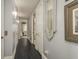 Hallway with dark wood flooring, neutral walls, decorative mirror, and framed artwork, creating an inviting path at 264 Seagate Ct, Dunedin, FL 34698