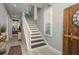 A view of the staircase featuring a white banister, black treads and shiplap accent walls at 264 Seagate Ct, Dunedin, FL 34698