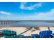 Tranquil waterfront views from a beach area with lounge chairs and pier at 264 Seagate Ct, Dunedin, FL 34698
