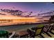 Picturesque waterfront scene at sunset with colorful lounge chairs by the water at 264 Seagate Ct, Dunedin, FL 34698