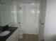 A clean bathroom featuring a shower-tub combination, vanity with a granite countertop and a modern mirror and lighting at 4118 Dellbrook Dr, Tampa, FL 33624