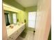 Bright bathroom with a vanity, a large mirror and window bringing in natural light at 4228 Presidential Avenue E Cir, Bradenton, FL 34203